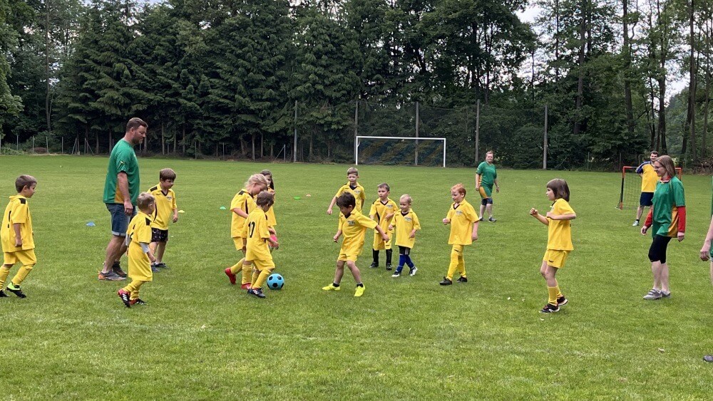 Žlutá přípravka TJ Sokol Stádlec proti zelené rodičovské smečce. Stádlecké hřiště, léto 2023